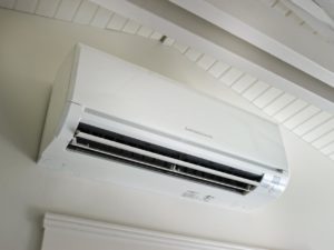 up close of white ductless mini-split system on white wall of residential area.