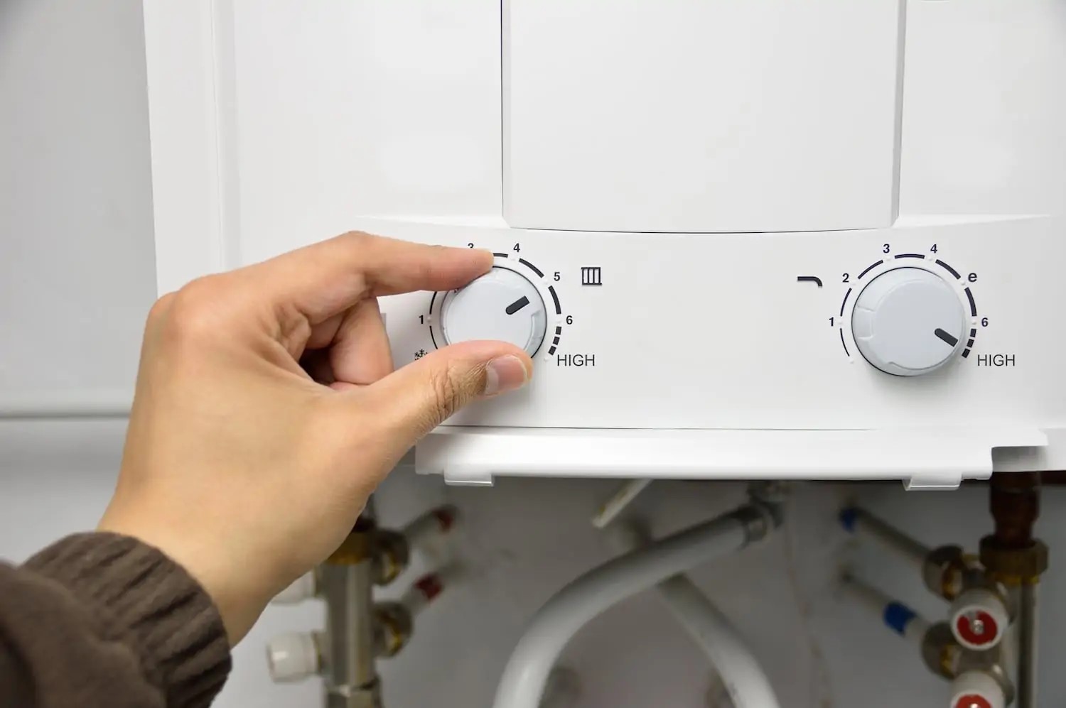 homeowner adjusting tankless water heater temperature settings