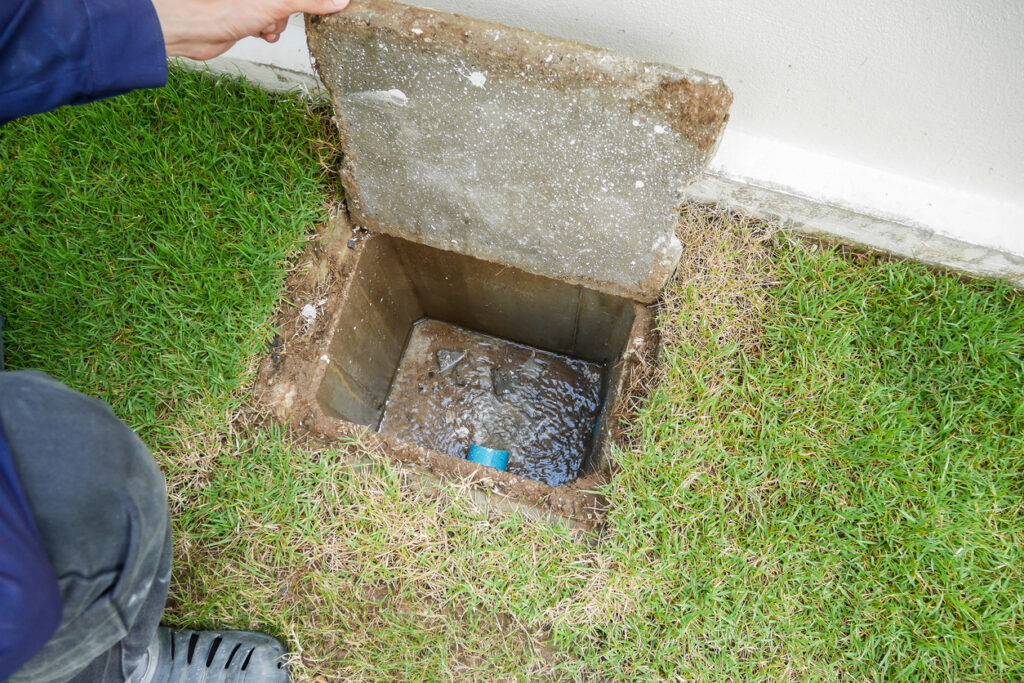 Plumber hand open sewer cover of new house