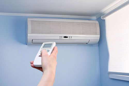 Homeowner using remote on ductless mini-split
